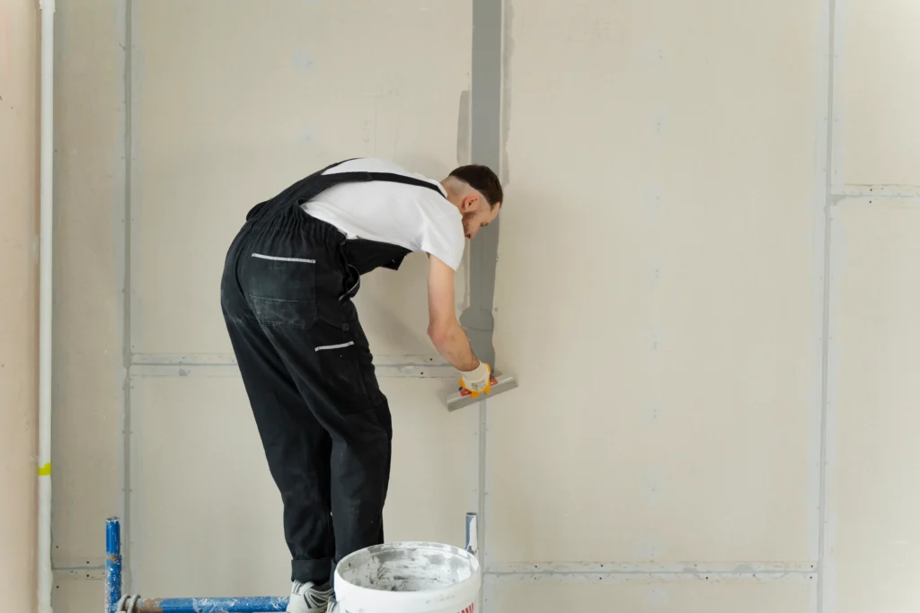 full shot construction worker using plastering trowel 1